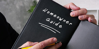 A person holding a book called Homeowner Guide