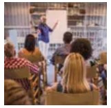 A woman is giving a presentation to a group of people.