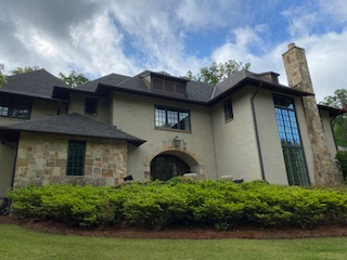 A home with a stone front and a large yard.